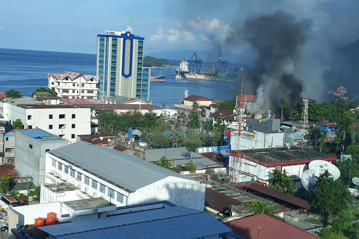 Asap mengepul dari salah satu bangunan yang dibakar massa dalam aksi protes yang berujung anarkis di Jayapura, Kamis (29/8/2019).