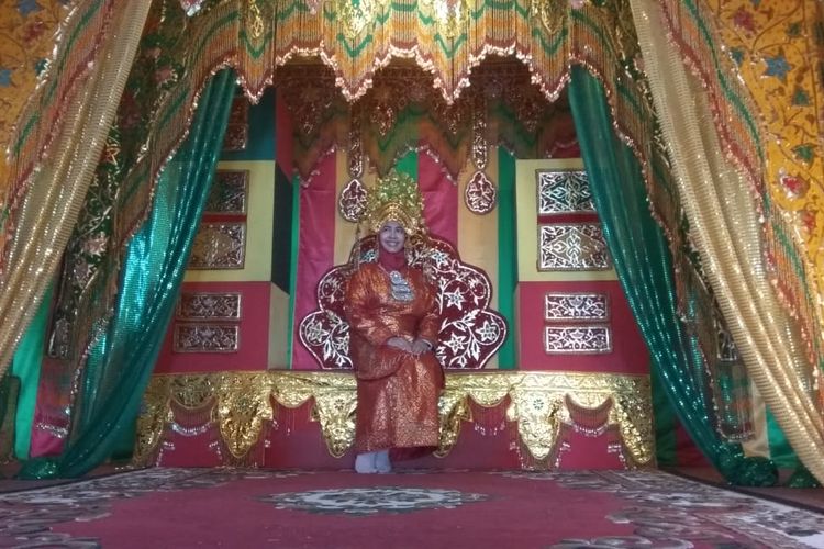 Wisatawan menjajal sensasi duduk di singgasana raja.