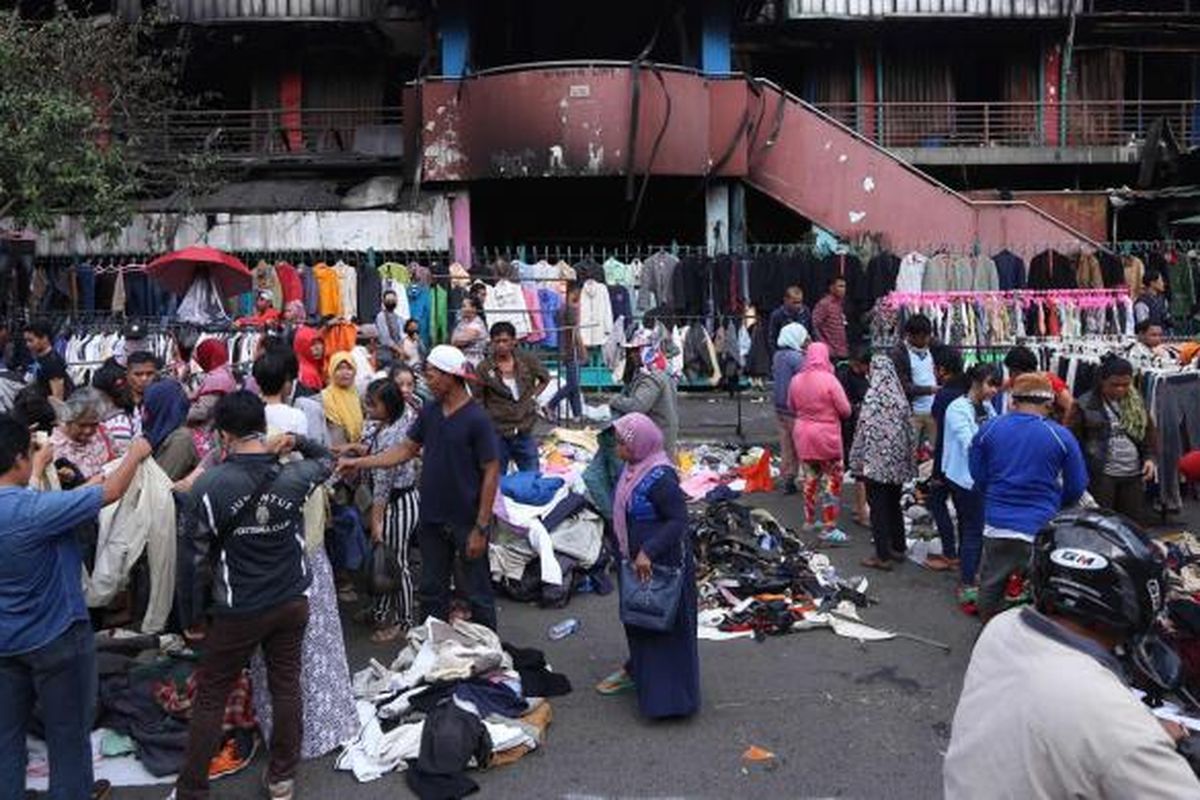 Para pedagang Pasar Senen berjualan kembali di trotoar depan Pasar Senen yang terbakar di Jakarta Pusat, Senin (23/1/2017). Pasca-kebakaran para pedagang menjual murah barang dagangannya untuk menarik pembeli.