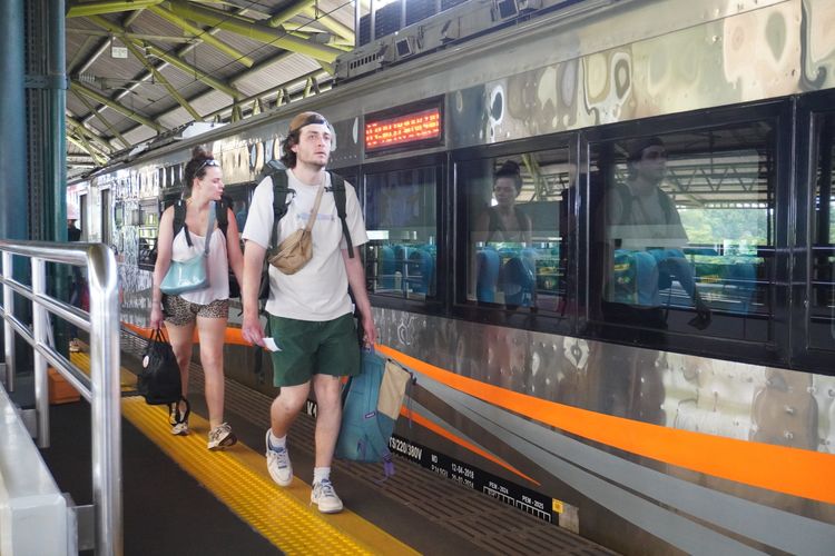 Ilustrasi turis asing menumpangi kereta api di Indonesia.