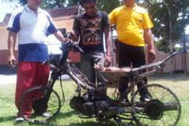Imam Rofi'i (22) (tengah) berikut sepeda motornya yang dibakar massa, saat diamankan di Mapolsek Kencong, Jember, Jawa Timur, Jumat (25/10/13).
