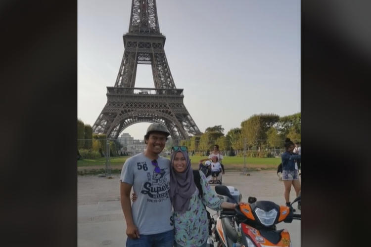 Foto Mohd Alfishahrin dan istrinya, Diana, di depan Menara Eiffel, Paris, Perancis. Keduanya viral karena keliling Eropa hanya bermodalkan sepeda motor bebek.