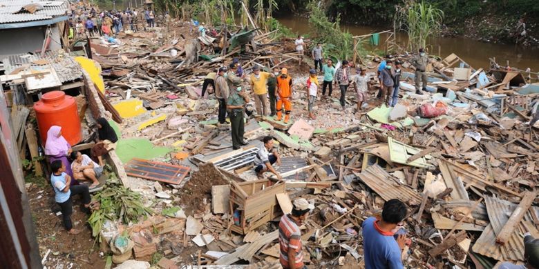 Petugas Satpol PP melalui dua back hoe membongkar bangunan semi permanen yang berada di area bantaran aliran Sungai Ciliwung di RW 01 Bukit Duri, Jakarta Selatan, Selasa (11/7/2017). Setelah bangunan diratakan dengan tanah, Balai Besar Sungai Ciliwung Cisadane (BBWSCC) akan memulai memasang sheet pile sebagai lanjutan proyek normalisasi Ciliwung.