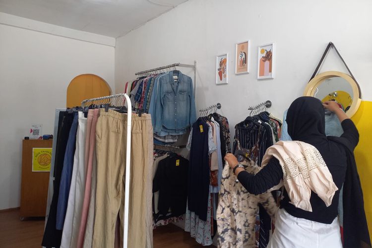 Salah satu pembeli pakaian thrift di Bilik Thrift Store sedang memilih baju model Korea, Rabu (30/6/2022).