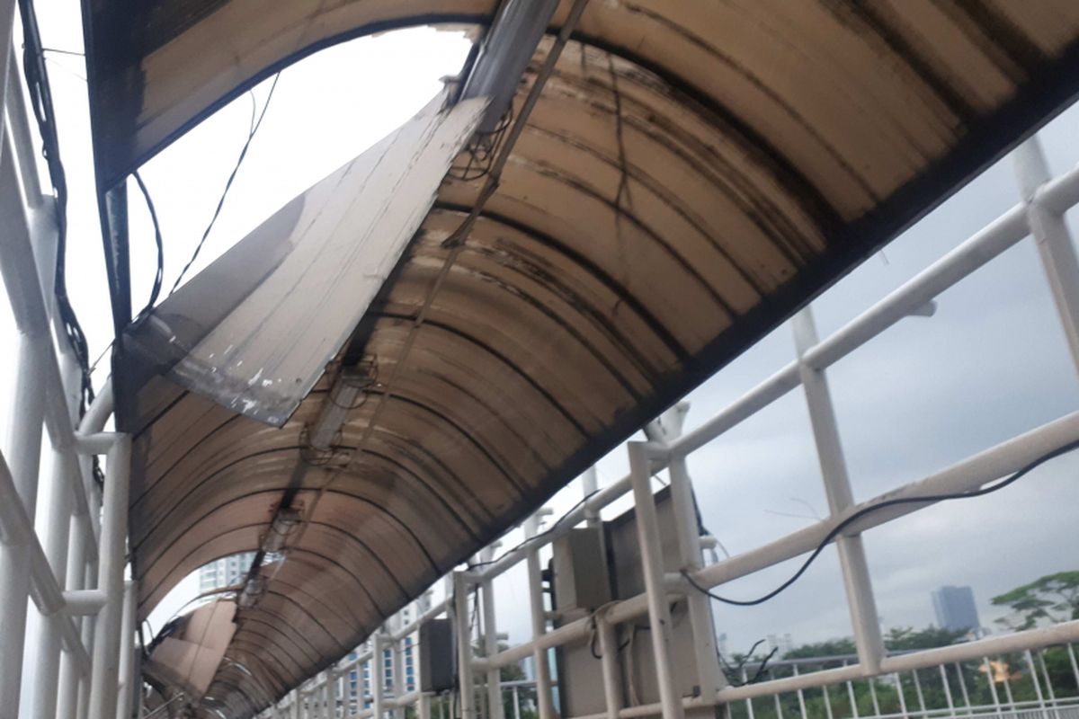 Kondisi jembatan penyebrangan orang (JPO) Dukuh Atas yang melintang di Jalan Sudirman, Jakarta Pusat, tampak rusak dan memprihatinkan.   Pantauan Kompas.com pada Rabu (12/12/2018), bagian atap JPO yang terbuat dari fiber sudah lepas.