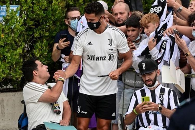 Megabintang Juventus Cristiano Ronaldo menyambut para fans setelah ia menjalani pemeriksaan di pusat medis Juventus di Turin pada 26 Juli 2021.