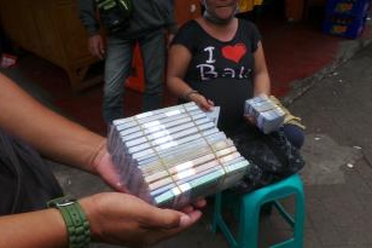 Linda, penjual uang receh yang mencari rupiah dari keuntungan menjual kembali rupiah di Terminal Kampung Rambutan, Jakarta Timur. Senin (5/8/2013).