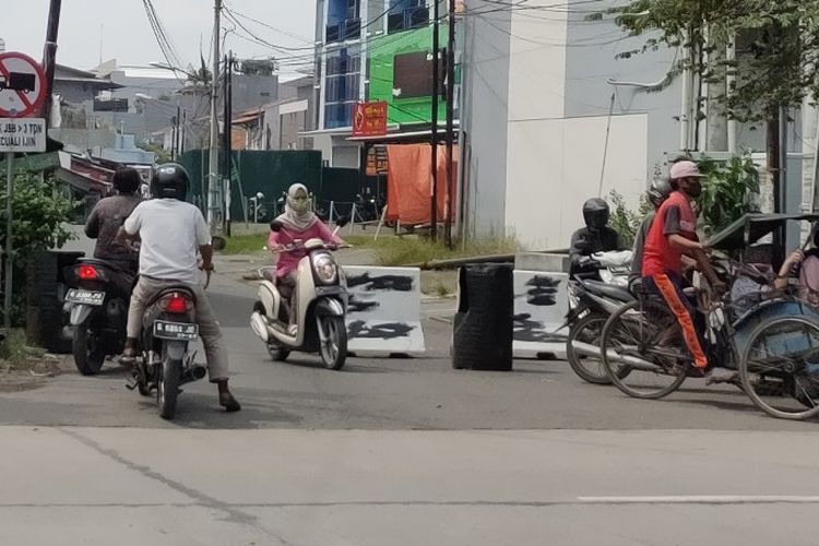 Sejumlah pengendara sepeda motor melintasi Jalan Cemara Kota Tegal yang sudah ditutup beton MCB pada pelaksanaan PSBB hari ketujuh, Rabu (29/4/2020)