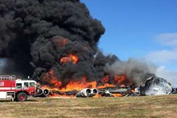 Tim pemadam kebakaran mencoba memadamkan api yang menjilat bangkai sebuah pesawat B-52 Stratofortress yang jatuh di Guam.