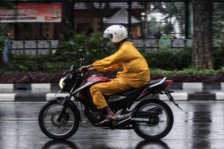 Pengendara sepeda motor mengenakan jas hujan saat terjadi hujan di Jalan Katedral, Sawah Besar, Jakarta Pusat, Minggu (22/12/2019). Badan Meteorologi, Klimatologi, dan Geofisika (BMKG) memberikan informasi dini cuaca ektrem yang akan melanda sejumlah wilayah di Indonesia pada hari Minggu (22/12/2019), dan Senin (23/12/2019).