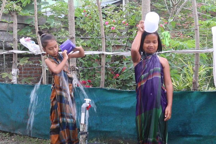 Anak-anak warga Dusun Pelita, Gampong Meunasah Mon, Krueng Raya, Kabupaten Aceh Besar sedang mandi di pekarangan rumah, selama ada bantuan sumur bor dari pertamina mereka tidak perlu lagi harus ke sungai saat mandi. 