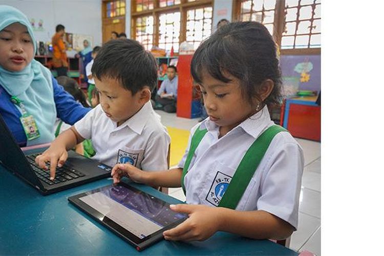 Nura Uma Annisa, guru komputer TK Islam Al-Azhar 22 Semarang, mendampingi anak muridnya dalam menggunakan tablet dan laptop untuk belajar, Selasa (17/12/2013)