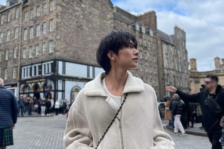 Joshua Hong mengenakan jaket shearling berwarna beige.