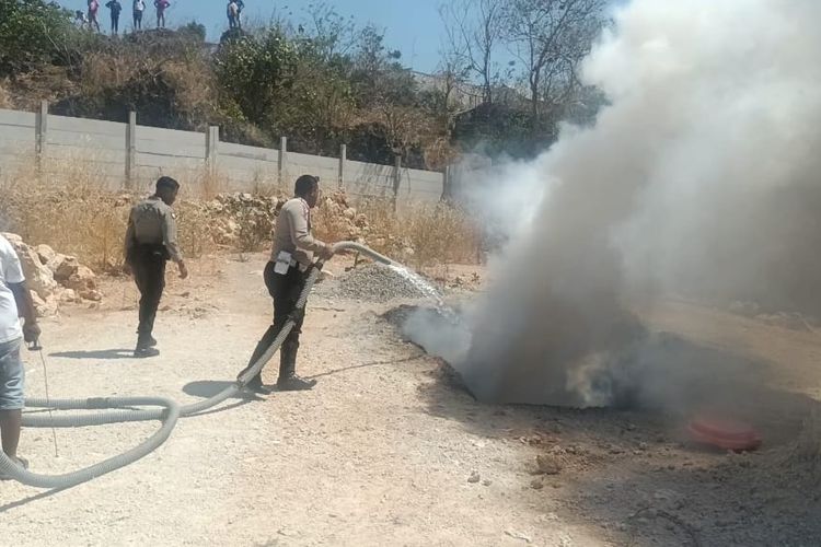 Polisi padamkan api dari sepeda motor yang dibakar warga, saat bentrokan pada, Jumat (15/9/2023) 