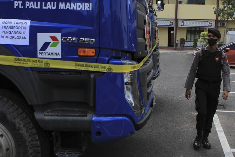 Seorang polisi melakukan pengecekan enam unit mobil tangki pembawa solar industri yang telah dioplos dengan asam sulfat dan minyak mentah ilegal saat diamankan di Polda Sumatera Selatan, Selasa (22/3/2022).