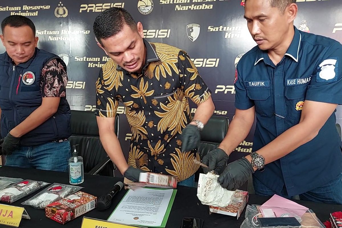 Kasat Narkoba Polres Metro Jakarta Barat, AKBP Akmal (tengah) memperlihatkan upaya kamuflase paket ganja yang disembunyikan dalam kemasan kopi instan di Mapolres Jakarta Barat, Jumat (23/9/2022). Paket dipesan mahasiswa di Sumedang dari Aceh.