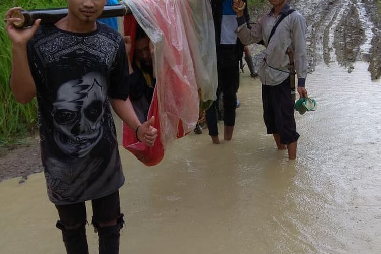 Junaedi (40) terpaksa ditandu saat akan dibawa ke Puskesmas Cikeusik, Kabupaten Pandeglang lantaran akses jalan rusak, Selasa (20/3/2019)