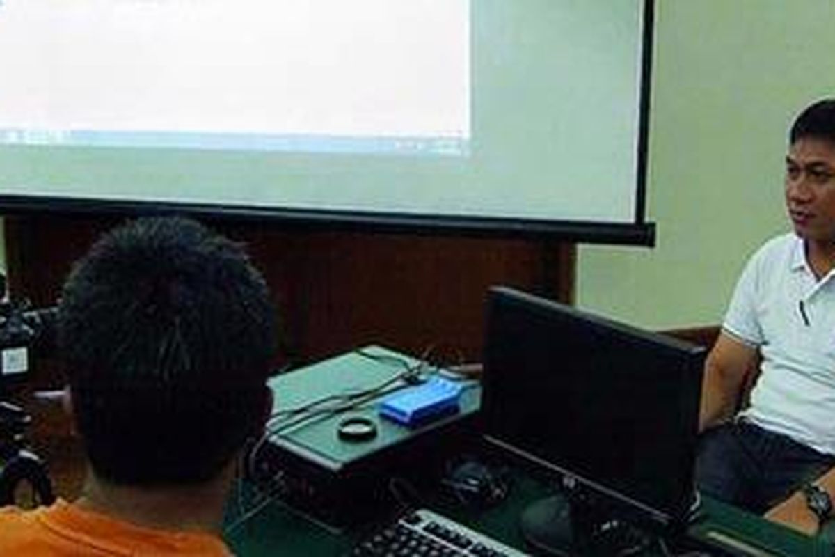 Komarudin (kanan), operator kependudukan, mencoba simulasi pembuatan kartu tanda penduduk elektronik, Minggu (31/7/2011), di Depok. Mereka mencoba memakai alat yang baru dikenalnya sebelum melayani masyarakat saat proses pembuatan KTP elektronik.