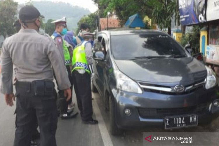 Polisi memeriksa mobil pemudik yang sempat menerobos pos pemeriksaan di Limbangan, Kabupaten Garut, Jawa Barat, Jumat (22/5/2020). (ANTARA/HO-Polres Garut)