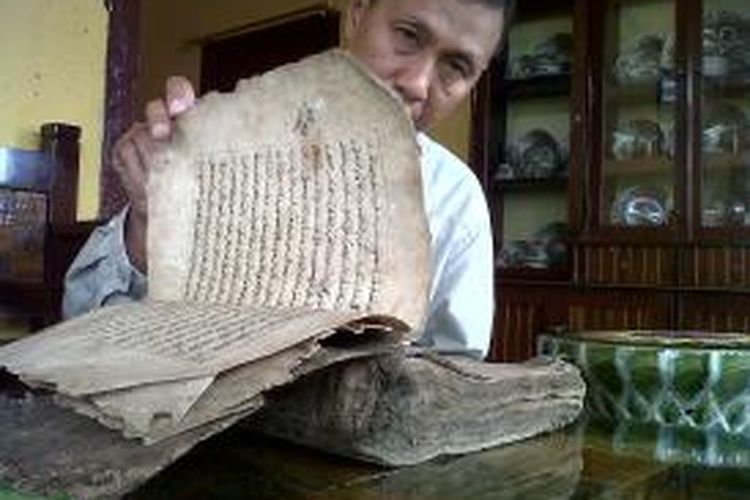 Seorang warga di Kabupaten Bone, Sulawesi Selatan tengah membuka Alquran berusia ratusan tahun berbahan kulit unta dan diyakini sebagai Alquran tertua di Bone. Minggu, (28/07/2013).