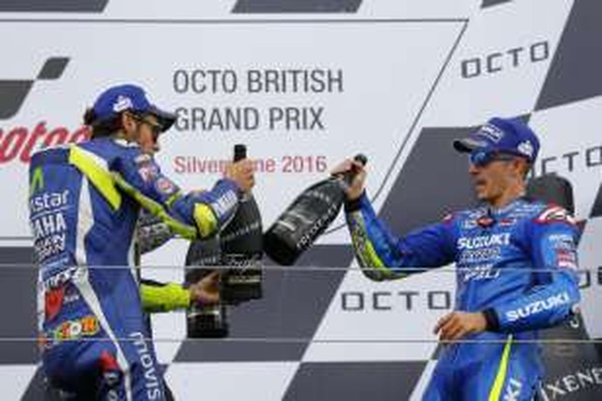 Pebalap Movistar Yamaha asal Italia, Valentino Rossi (kiri), melakukan tos dengan pebalap Suzuki Ecstar asal Spanyol, Maverick Vinales, di atas podium Sirkui Silverstone, Inggris, Minggu (4/9/2016). Vinales memenangi balapan, sementara Rossi finis di urutan ketiga.