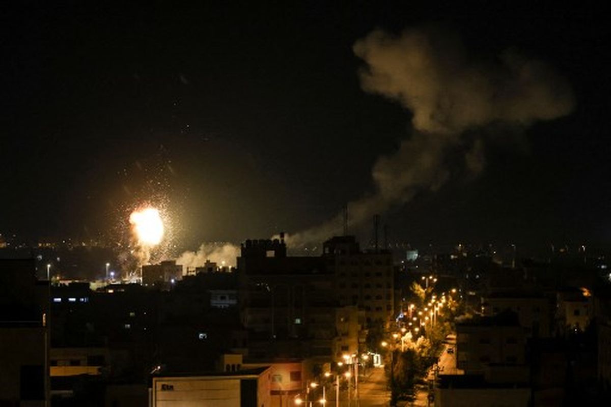 Api dan asap mengepul di atas gedung-gedung di Kota Gaza saat Israel melancarkan serangan udara ke kantong Palestina pada Jumat (27/1/2023). Israel melancarkan serangan udara di Gaza pada 27 Januari sebagai tanggapan atas tembakan roket militan dari kantong Palestina, saat ketegangan meningkat menyusul serangan tentara paling mematikan di Tepi Barat yang diduduki selama bertahun-tahun. 