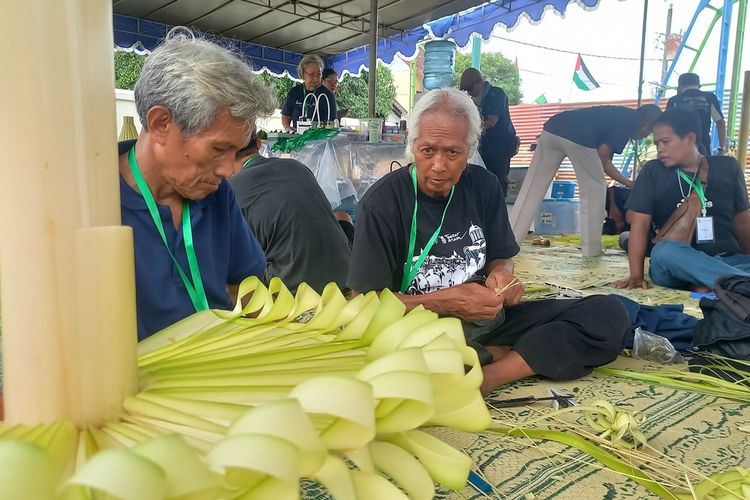 Sejumlah orang sedang merangkai janur menjadi ornamen-ornamen dhaup ageng di sekitar Pura Pakualaman, Senin (8/1/2024)