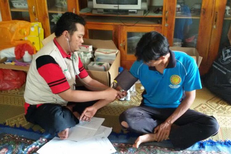 Petugas medis tengah memeriksa tensi darah warga di posko kesehatan bencana tanah longsor di Desa Banaran, Kecamatan Pulung, Kabupaten Ponorogo, Kamis ( 6/4/2017).