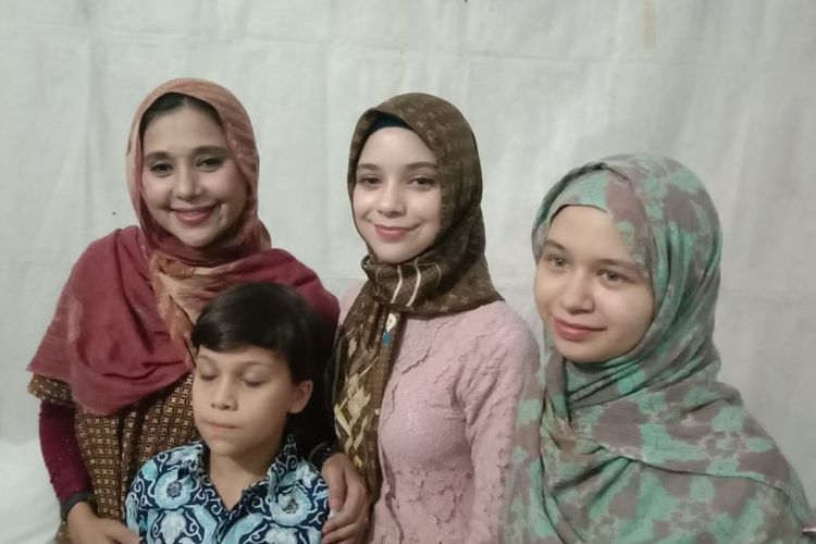 Ayu Azhari (kiri) mengajak anak lelakinya, Lennon Tramp, dan kedua anak perempuannya, Isabelle Tramp (tengah) dan Mariam Nur Al Iman (kanan), dalam acara Festival Jajanan Minang yang digelar di Lebak Bulus, Jakarta Selatan.