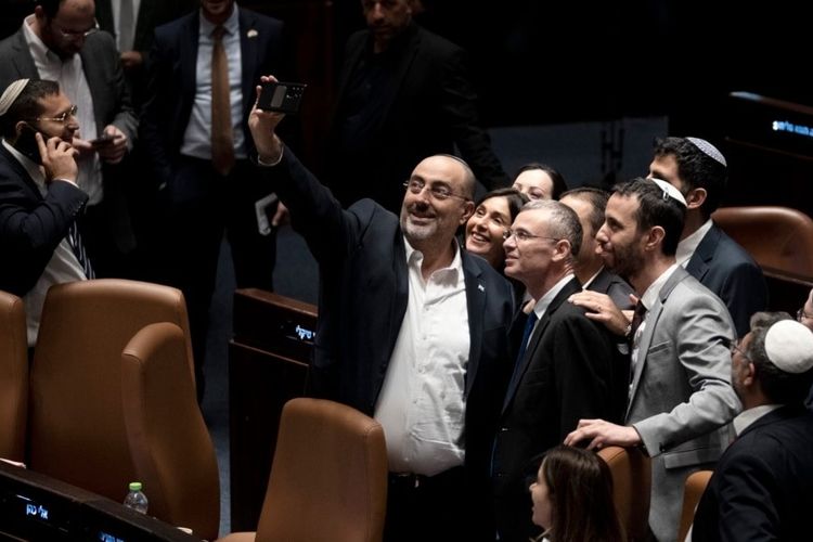 Para anggota parlemen Israel merayakan dengan berswafoto setelah Knesset menyetujui bagian penting dari rencana pemerintah untuk mereformasi sistem peradilan negara itu dalam voting di Yerusalem pada Senin (24/7/2023). 