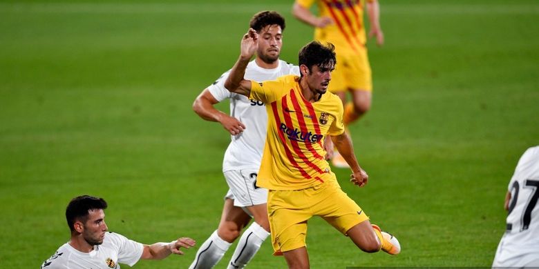 Penyerang Portugal Barcelona Francisco Trincao (tengah) bersaing dengan penyerang Spanyol Nastic Joel Lasso selama pertandingan sepak bola persahabatan antara FC Barcelona dan Nastic di stadion Johan Cruyff di Sant Joan Despi, dekat Barcelona, pada 12 September 2020.