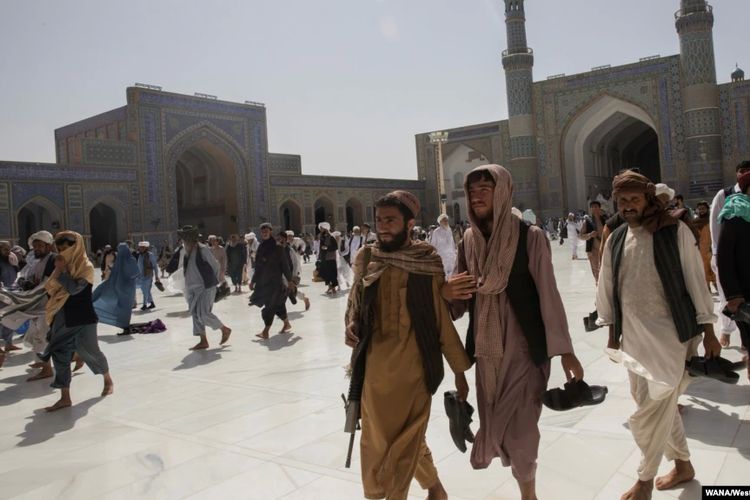 Para pria Afghanistan berjalan di sebuah masjid di Herat, Afghanistan, 10 September 2021. 
