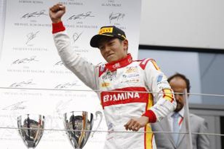 Pebalap Campos Racing asal Indonesia, Rio Haryanto, merayakan kemenangannya pada sprint race GP2 Austria saat berada di podium Sirkuit Red Bull, Spielberg, Minggu (21/6/2015)