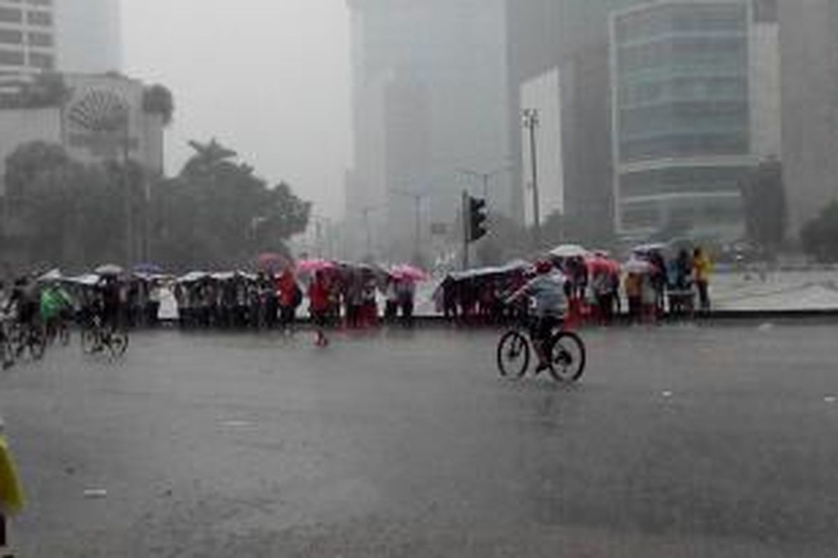 Hujan deras turun ketika car free day di Bundaran Hotel Indonesia, Minggu (1/1/2015).