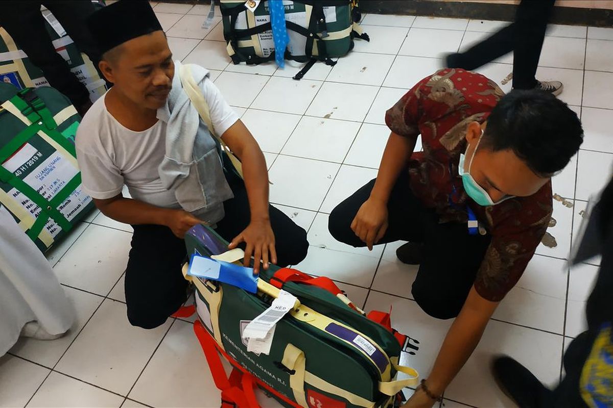 Petugas hendak menggeledah koper jemaah haji yang berisi barang-barang tak sesuai syarat di Asrama Haji Embarkasi Bekasi, Kamis (11/7/2019).