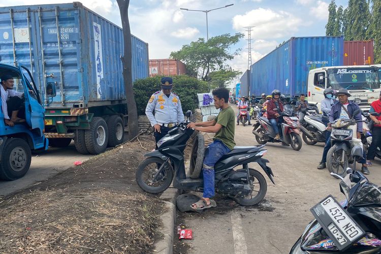 Salah satu pengendara sepeda motor yang melintasi Jalan Akses Marunda menerapkan berbagai cara agar bisa menerobos kemacetan di jalan penghubung Bekasi dan DKI Jakarta ini.