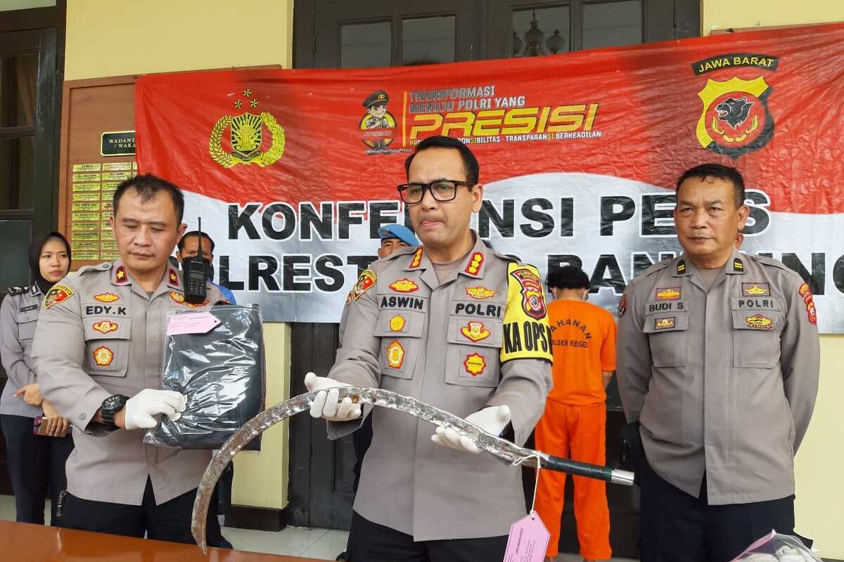 Kapolrestabes Bandung Kombes Aswin Sipayung tengah memperlihatkan barang bukti berupa parang besar yang digunakan pelaku untuk melakukan pencurian dan pengeroyokan terhadap pelaku di Jala Pasirluyu, Kota Bandung. Polisi menangkap dua pelaku utama, dan tegah mengejar sebagian pelaku lainnya, Senin (2/1/2023).