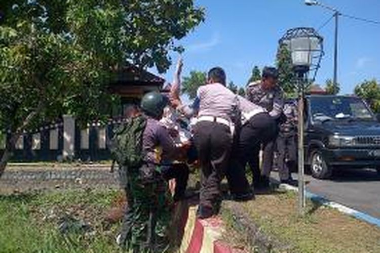 Supriyanto, anggota Polres Bangkalan saat dievakuasi oleh rekannya setelah terbakar obat mercon, Rabu (17/7/2013).