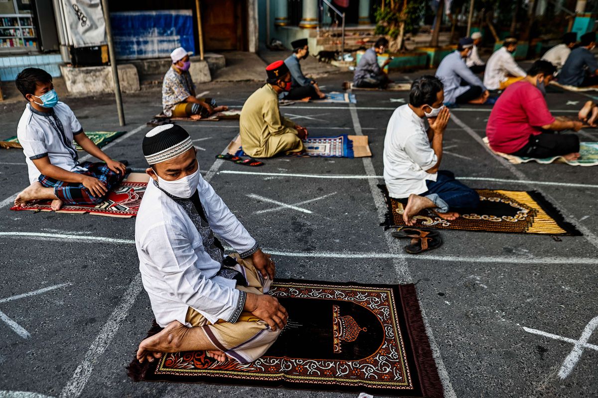 Umat muslim melaksanakan shalat Idul Adha di Jalan Pramuka Raya, Cempaka Putih, Jakarta Timur, Jumat (31/7/2020). Umat muslim menggelar shalat Idul Adha secara berjamaah dengan menerapkan protokol kesehatan seperti jaga jarak serta wajib mengenakan masker guna mencegah penyebaran COVID-19.