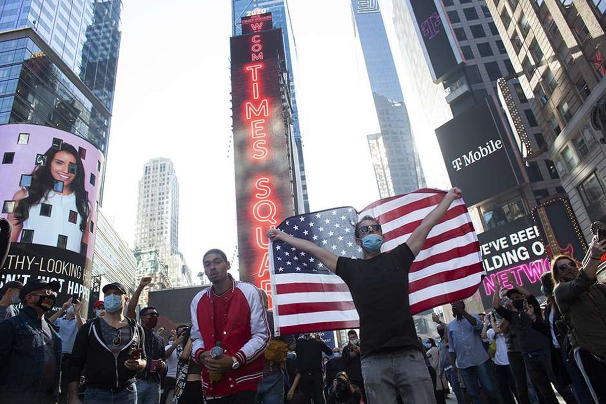 Warga merayakan kemenangan Joe Biden pada pemilihan presiden Amerika Serikat (AS) 2020 di Times Square, New York, AS, Sabtu (7/11/2020). Joe Biden dipastikan melenggang ke Gedung Putih dengan 290 suara elektoral yang diraihnya sejauh ini, mengakhiri kepemimpinan 4 tahun Donald Trump.