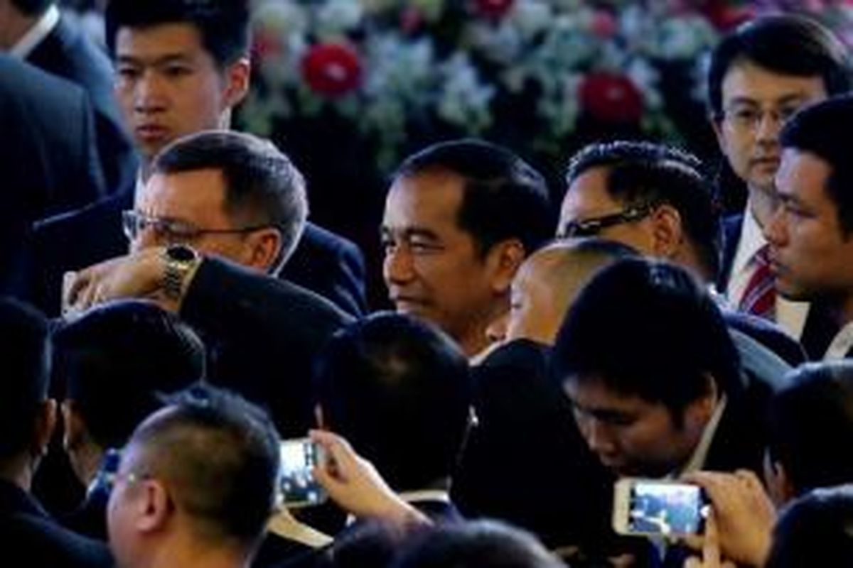 Para delegasi menggunakan smartphone, berebut selfie dengan Presiden Joko Widodo (Jokowi), usai menyampaikan pidato di acara APEC CEO Summit di China National Convention Center di Beijing, 10 November 2014.