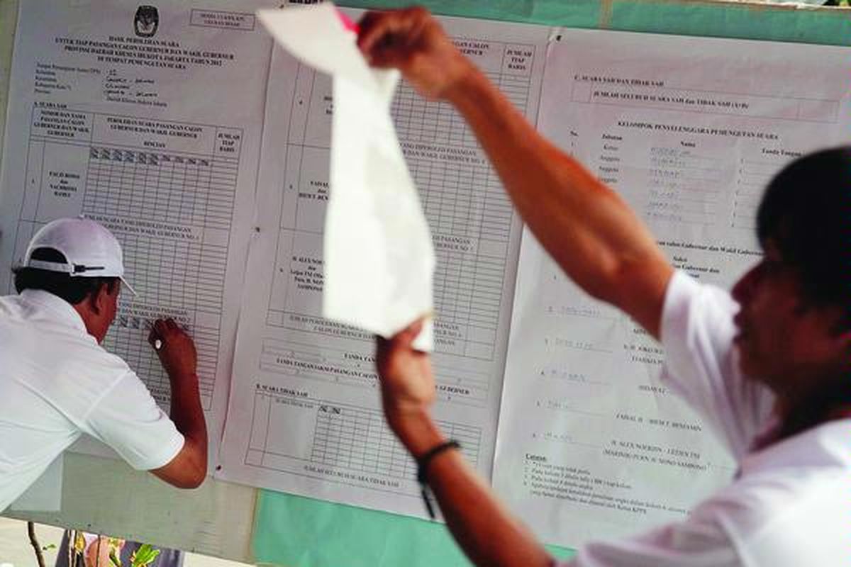 Petugas TPS 022 Gandaria Selatan, Jakarta Selatan, menghitung perolehan suara Pilkada DKI Jakarta, Rabu (11/7). Di TPS tersebut, pasangan Foke-Nara dan Jokowi-Basuki bersaing ketat, dengan perolehan suara 136 dan 125 suara.