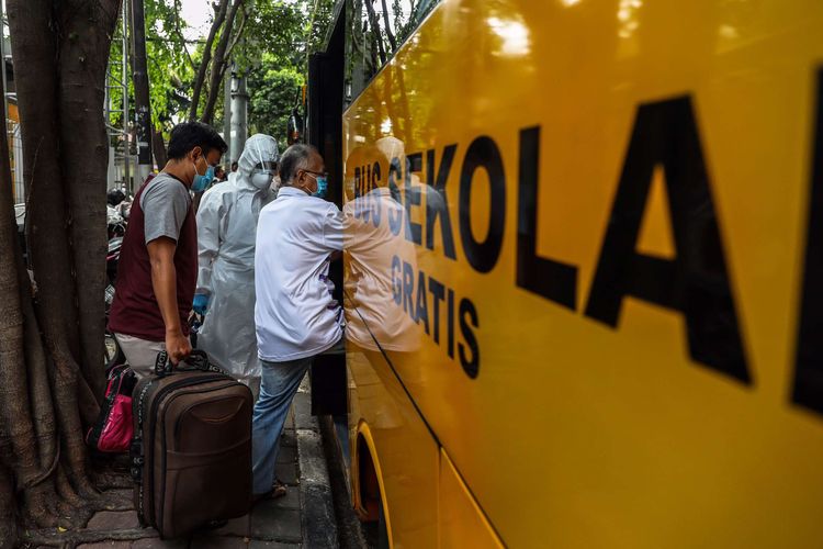 Pasien positif Covid-19 orang tanpa gejala (OTG) memasuki bus sekolah di Puskesmas Kecamatan Tanah Abang, Jakarta Pusat, Jumat (25/9/2020). Total sebanyak 21 Pasien positif Covid-19 orang tanpa gejala (OTG) yang dipindahkan ke Rumah Sakit Darurat Wisma Atlet untuk di karantina.