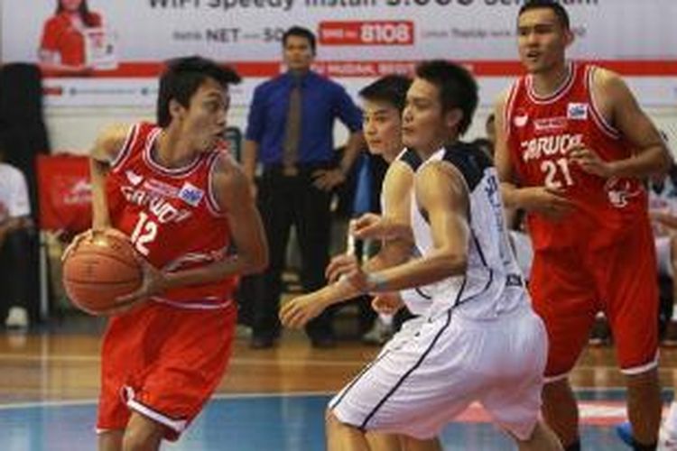 Pemain Garuda Kukar Bandung, Rizal Mohammad (kiri) membawa bola melewati pemain Satya Wacana Metro LBC Bandung pada pertandingan NBL Seri I, di GOB Bimasakti, Malang, Minggu (17/11/2013).