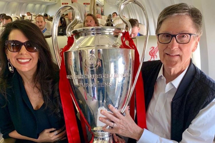 Pemilik Liverpool dan Boston Red Sox, John W Henry, berpose dengan trofi Liga Champions 2019 yang dimenangkan The Reds seusai mengalahkan Tottenham.