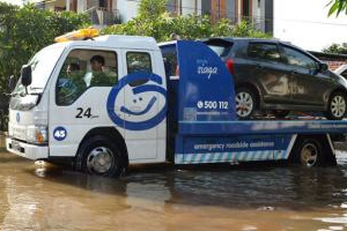 Mobil pelanggan diselamatkan oleh perusahaan Asuransi akibat banjir di Ibukota, Senin-Selasa (9-10/2/2015).