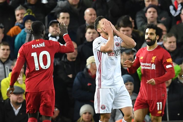 Bek Sheffield United George Baldock (putih) bereaksi ketika penyerang Liverpool Mesir Mohamed Salah (kanan) merayakan gol dengan rekan satu timnya dalam pertandingan Liga Inggris antara Liverpool vs Sheffield United di Anfield pada 2 Januari 2020.