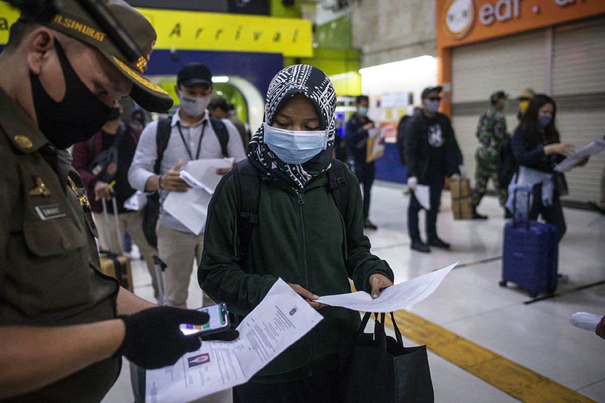 Petugas melakukan pemeriksaan dokumen penumpang Kereta Api Luar Biasa (KLB) Gambir-Surabaya Pasarturi saat tiba di Stasiun Gambir, Jakarta, Selasa (26/5/2020). Gubernur DKI Jakarta Anies Baswedan telah mengeluarkan Pergub DKI Nomor 47 Tahun 2020 tentang Surat Izin Keluar-Masuk (SIKM) sebagai syarat mutlak yang harus dimiliki oleh warga untuk keluar atau masuk ke wilayah Jakarta yang bertujuan untuk menekan angka kasus Covid-19.