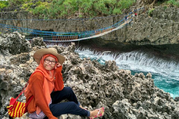 pengunjung berpose di tepian Pulau Kalong