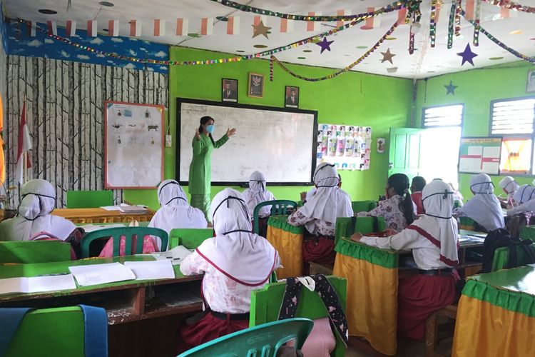 Irma Sinaga, Guru SDN 158/VIII Rimbo Mulyo Tebo, Jambi, sedang mengajar pada pertemuan tatap muka di kelas. 